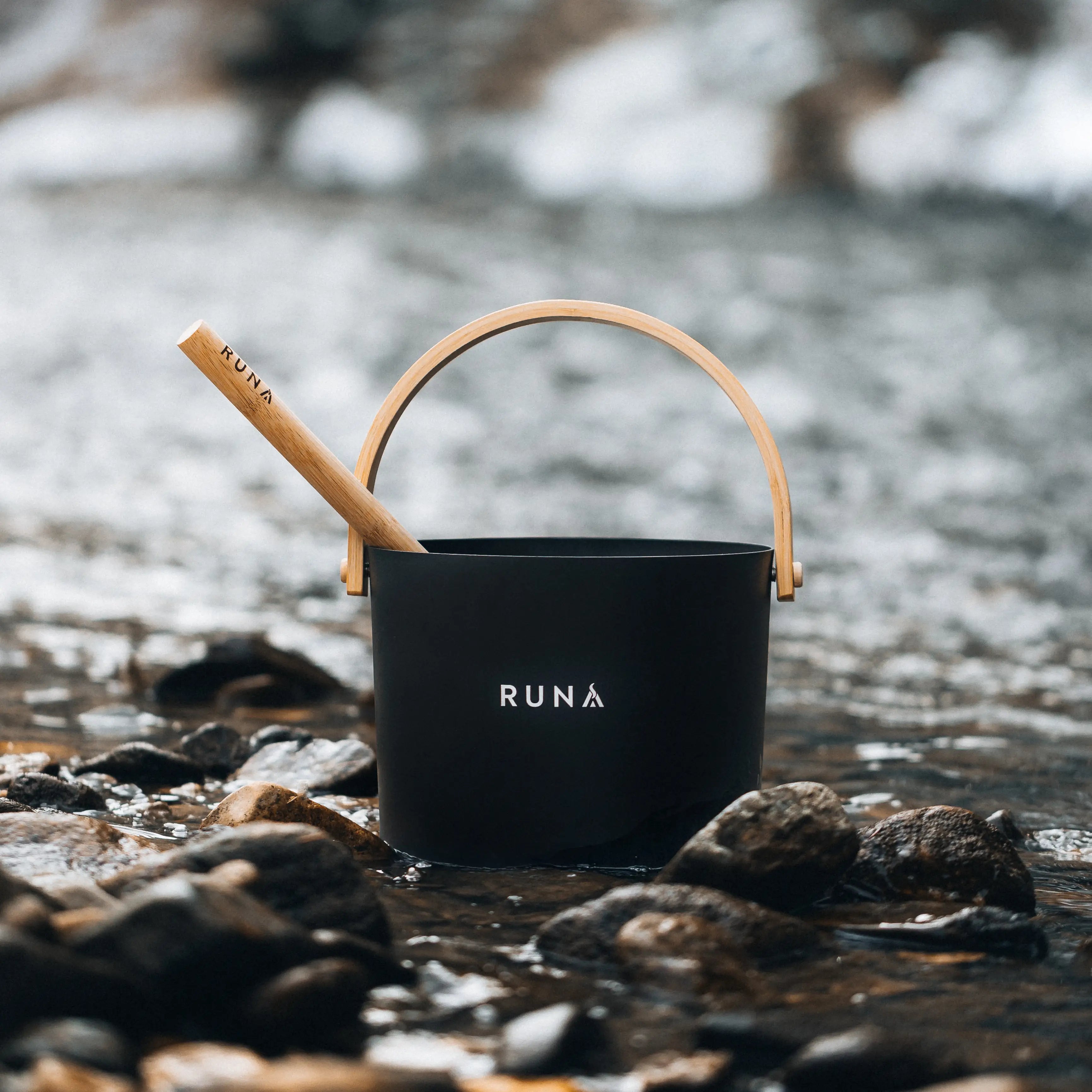 Aufgusseimer mit Aufgusskelle am Fluss